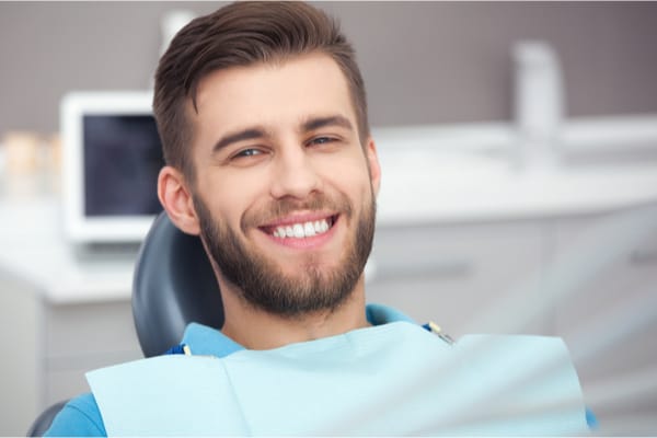 Male sitting in dentist chair smiling