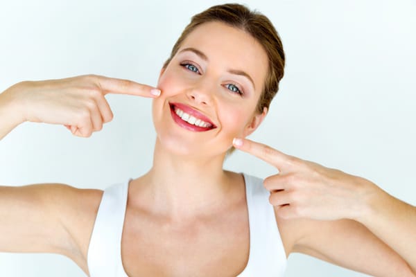 woman pointing at her smile