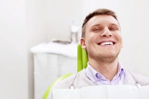 White male smiling in a dentist chair