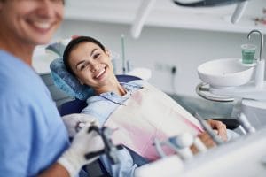 Woman smiling in dentist chair laid back