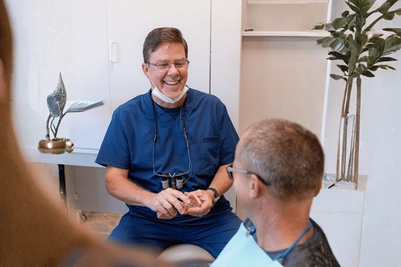 Dr. Kevin Huelsman smiling with patient at dental clinic in Columbus Ohio